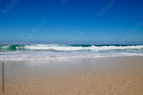 Welle am Strand bei blauem Himmel photo