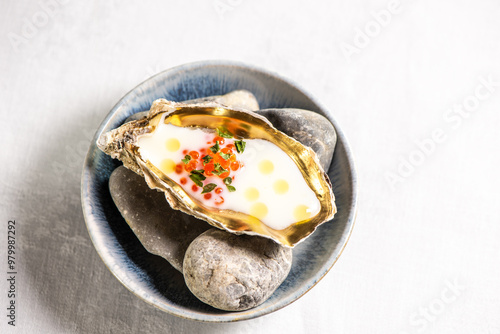 Golden oyster with red caviar and herb photo