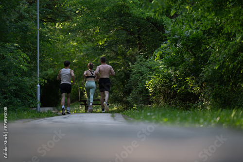 A group of sportspeople jogging together on a serene forest path, promoting fitness, health, and a connection with nature.