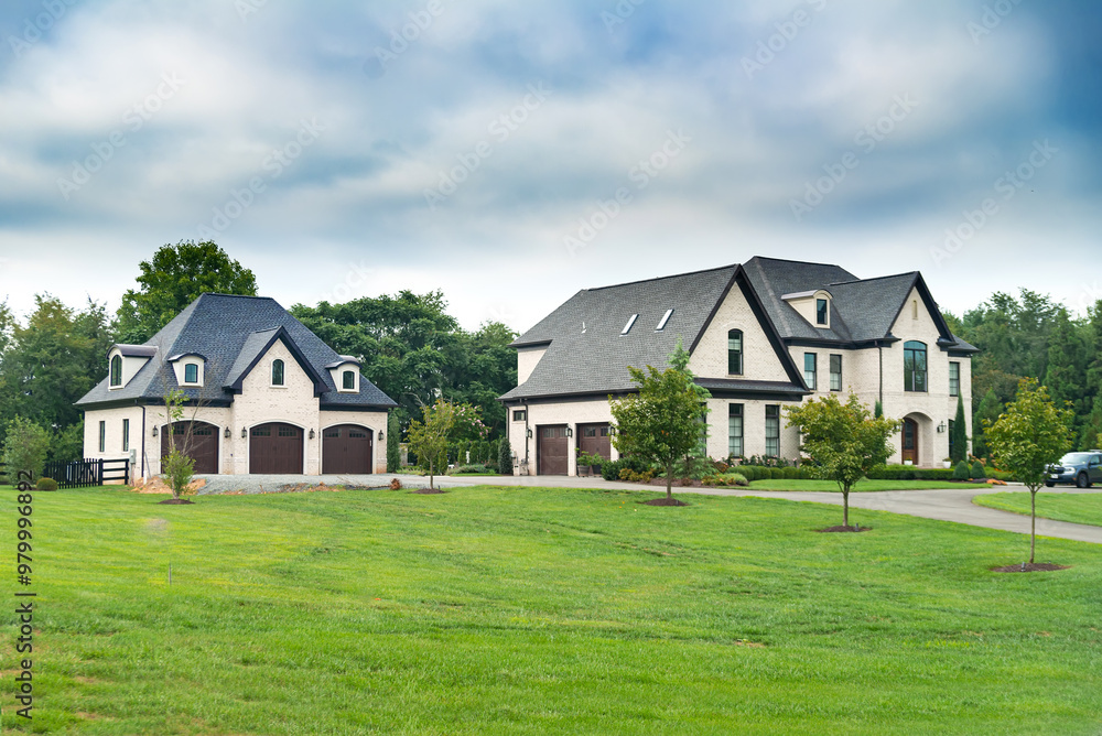 Large modern country single family home with large lawn under blue skies. Large modern country single family home with large lawn under blue skies.