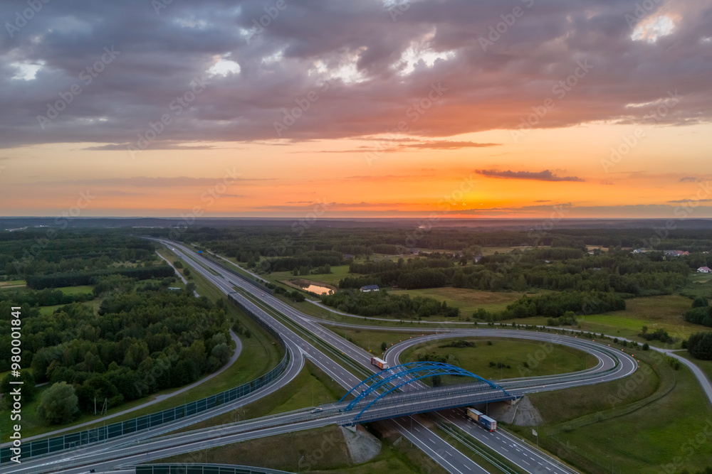 Aerial view of a scenic landscape with highways and a sunset over lush greenery Aerial view of a scenic landscape with highways and a sunset over lush greenery