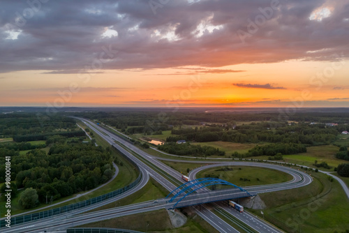 Aerial view of a scenic landscape with highways and a sunset over lush greenery