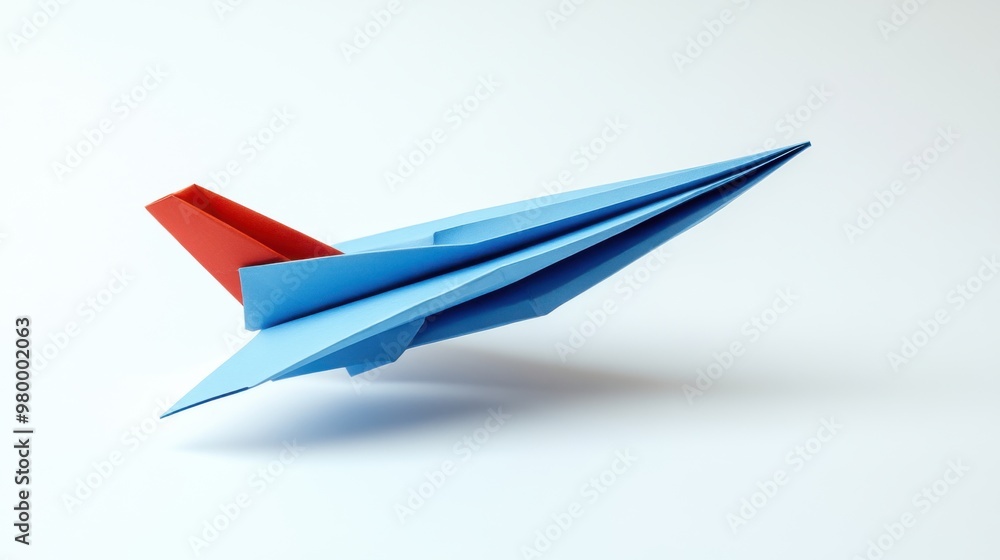 Creative Blue and Red Paper Airplane Model Against a White Background. Creative Blue and Red Paper Airplane Model Against a White Background.