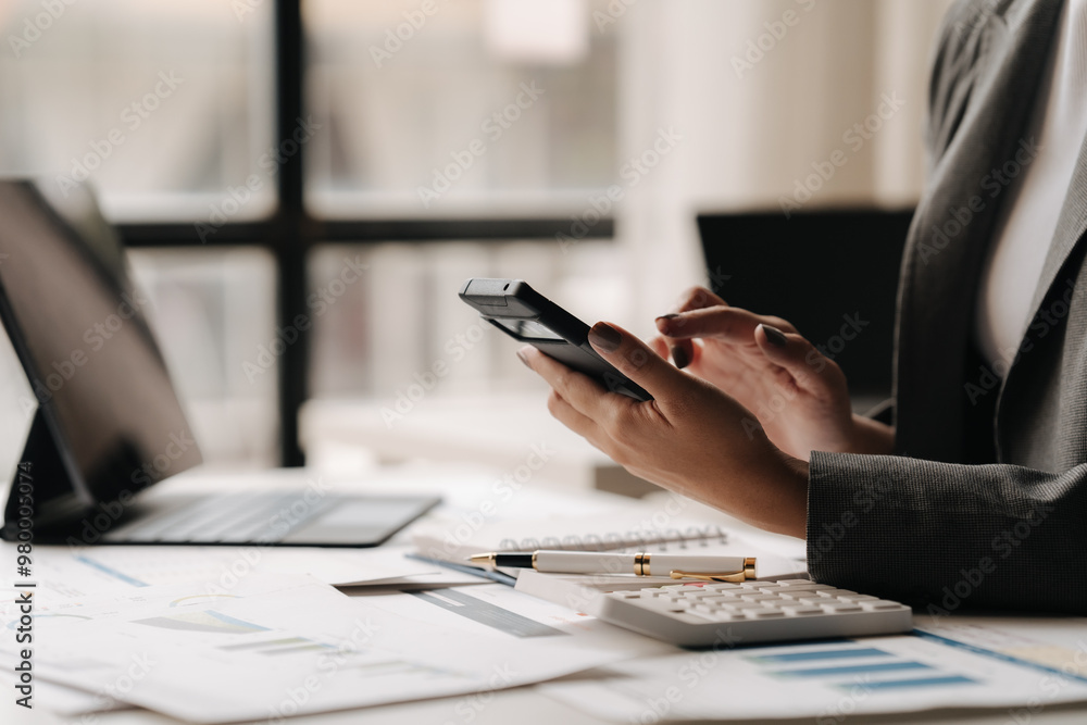 Fototapeta premium Mobile Strategy Session: Businesswoman Analyzing Data on Smartphone in Modern Office 