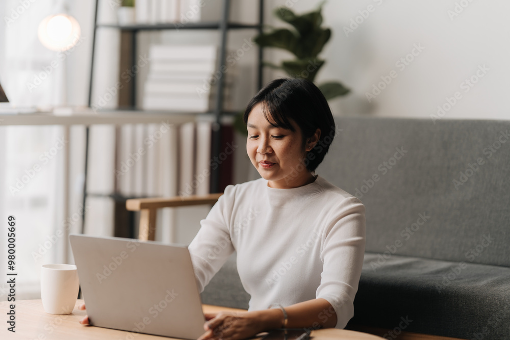 Focused Flow: A serene woman finds her rhythm working from home, effortlessly navigating her laptop in a cozy and productive setting. Focused Flow: A serene woman finds her rhythm working from home, effortlessly navigating her laptop in a cozy and productive setting.