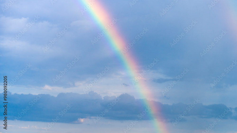 Blue summer sky with beautiful rainbow over the clouds Blue summer sky with beautiful rainbow over the clouds
