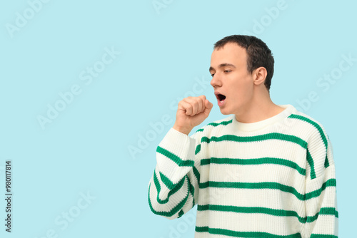 Ill young man coughing on b...
