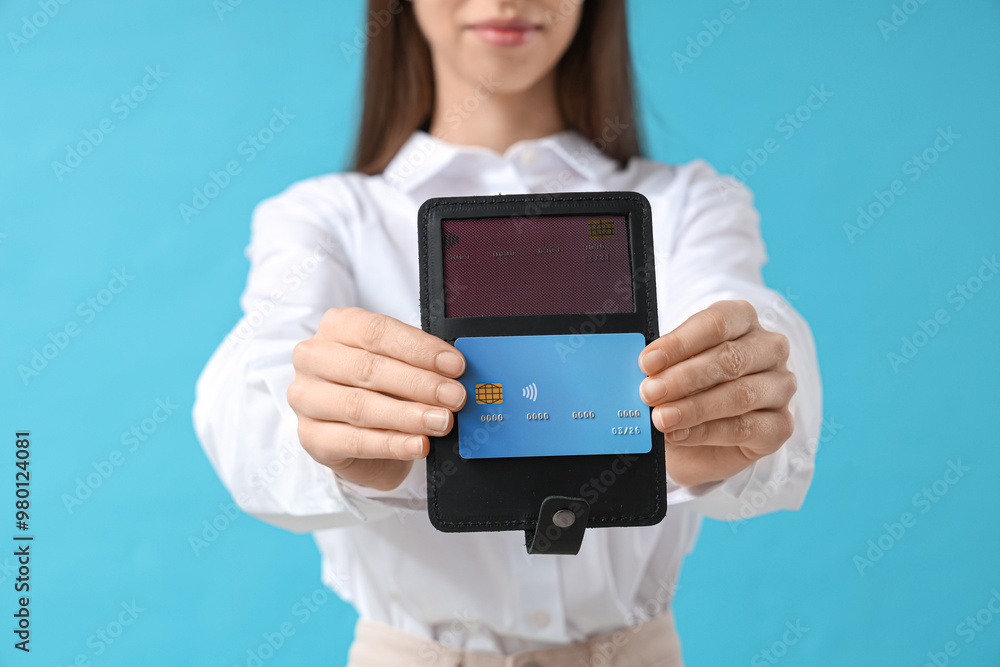 Female hands with credit card holder on blue background Female hands with credit card holder on blue background