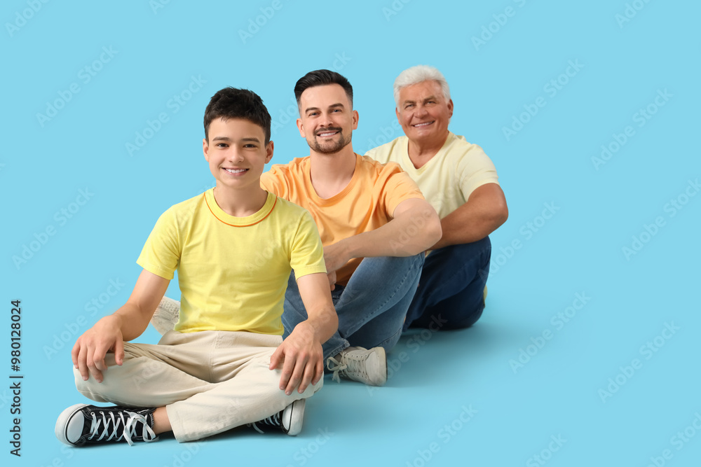 Teenage boy with his dad and grandfather sitting on blue background Teenage boy with his dad and grandfather sitting on blue background