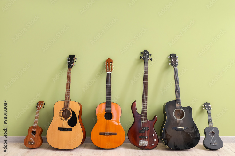 Fototapeta premium Different guitars near green wall