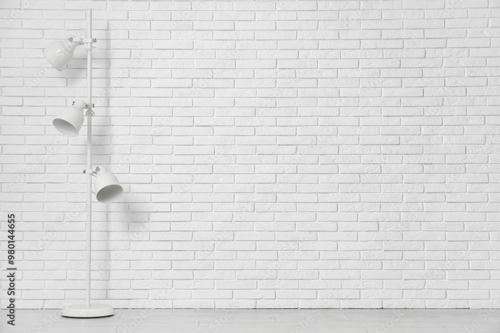 Floor lamp near white brick wall in room Floor lamp near white brick wall in room