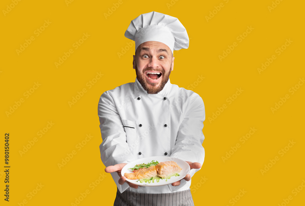 Excited Chef Man Showing Plate Serving Salmon Fish Dish Posing On Black Background. Studio Shot Excited Chef Man Showing Plate Serving Salmon Fish Dish Posing On Black Background. Studio Shot