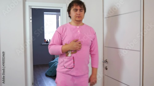 Sleepy, tired, disheveled man in pink pajamas walks staggering with eyes closed, no energy, vitamin deficiency, burnout Wake up in morning sluggish and without energy unbalanced diet, lack of activity