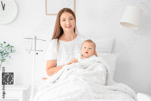 Young mother with her newborn baby in maternity hospital