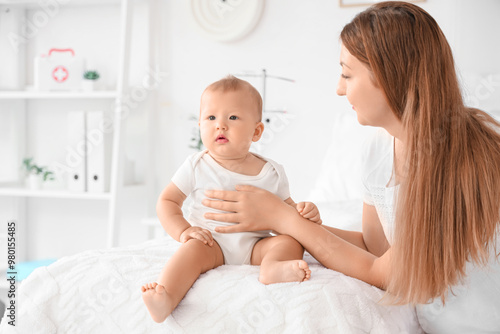 Infant baby sitting on bed ...