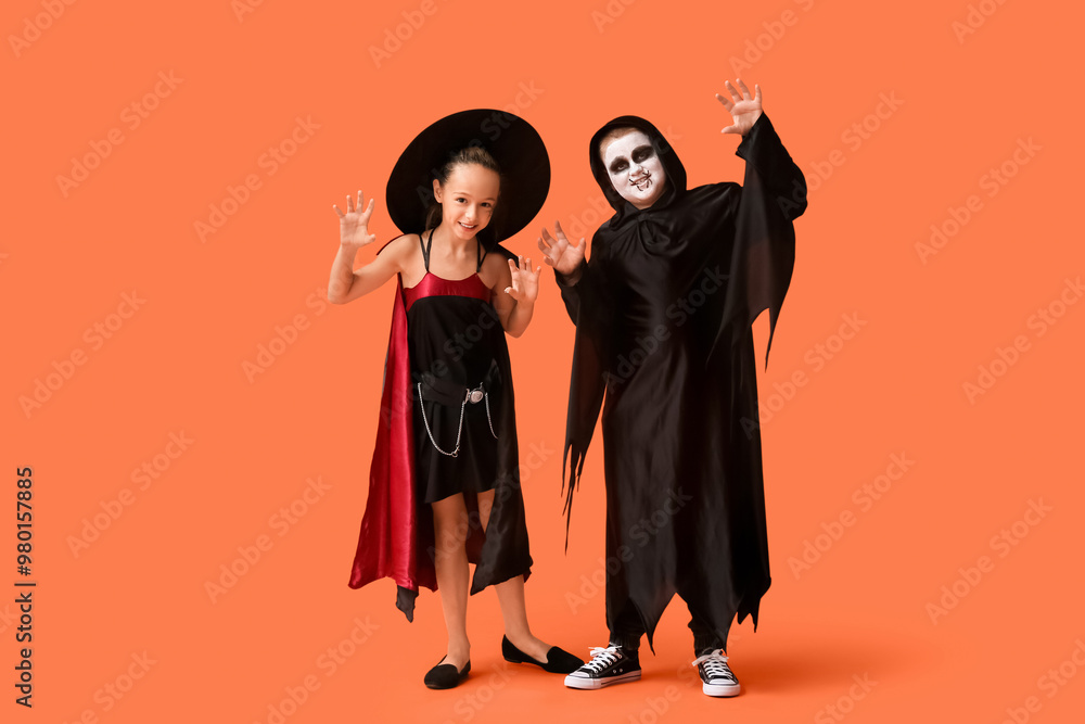Scary kids dressed for Halloween on orange background Scary kids dressed for Halloween on orange background