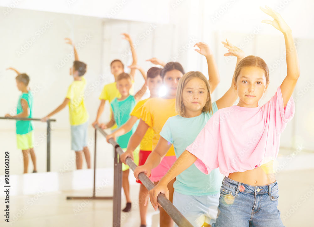 Fototapeta premium Youth girls and boys training ballet moves in studio.