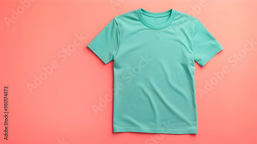 A vibrant turquoise t-shirt laid flat on a coral background, perfect for showcasing casual summer fashion styles. photo