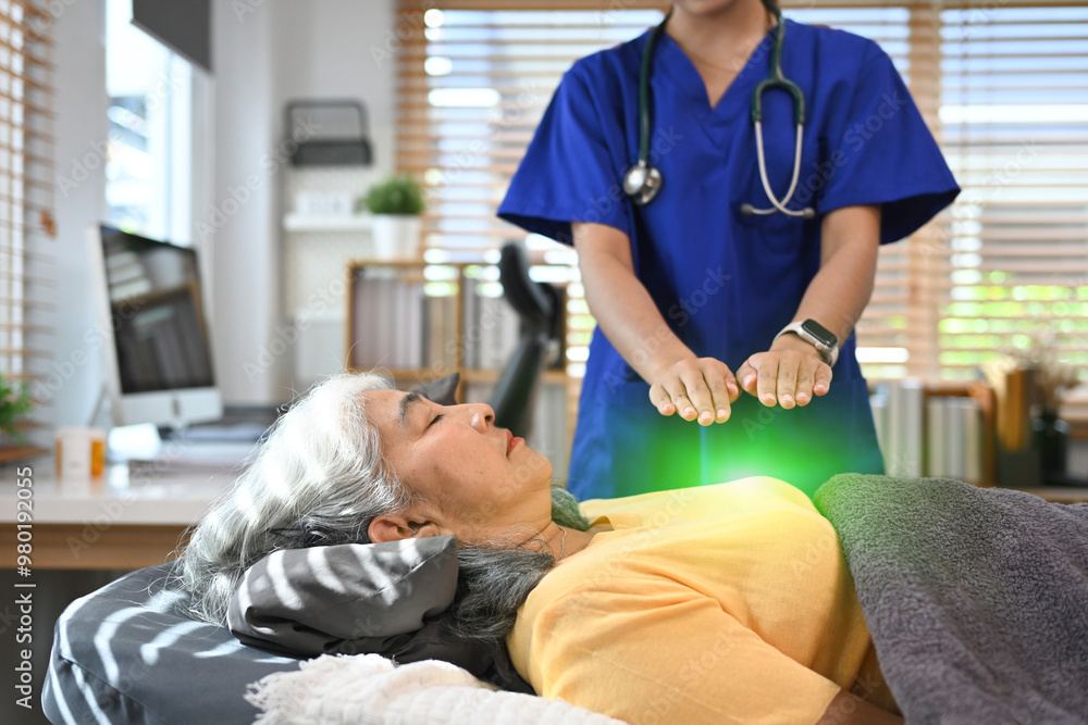 Calm senior woman receiving reiki healing therapy on head. Alternative therapy treatment and Reiki technique concept Calm senior woman receiving reiki healing therapy on head. Alternative therapy treatment and Reiki technique concept