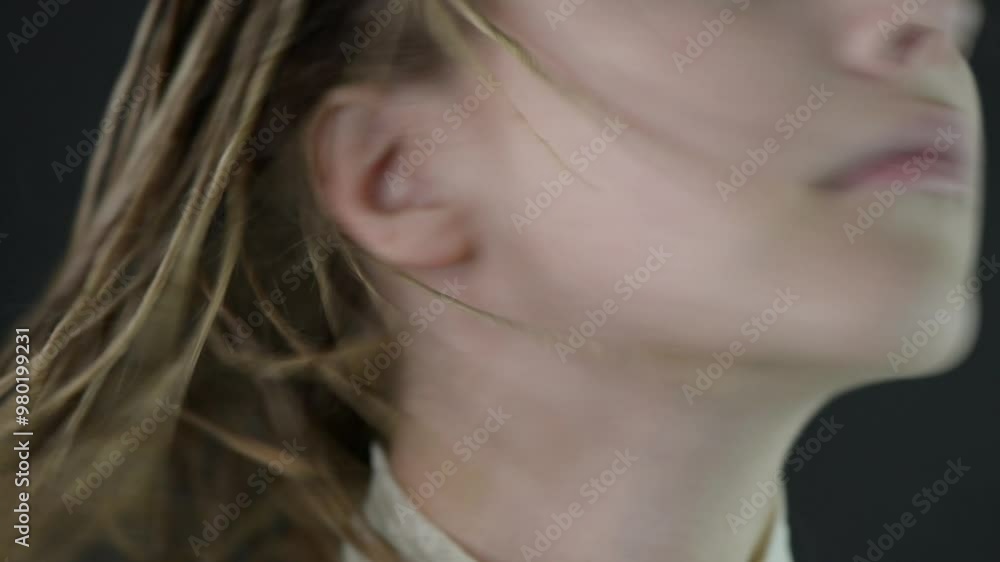 Beautiful young woman with clean skin and long blond hair waves her hair and looks to the camera. Face of young woman with big blue eyes no make-up. Beautiful young woman with clean skin and long blond hair waves her hair and looks to the camera. Face of young woman with big blue eyes no make-up.