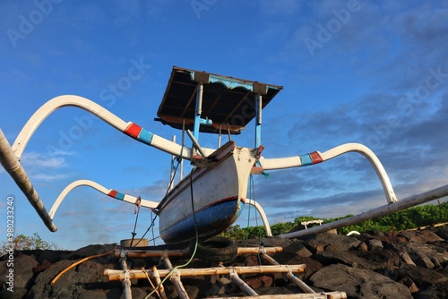 two traditional fishing boats anchored on the beach in the morning photo