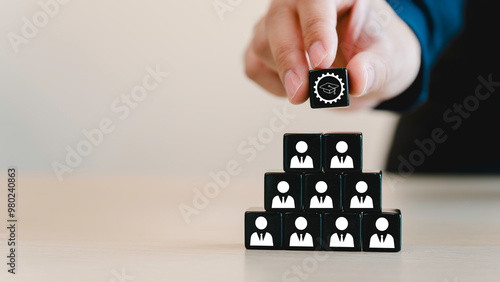 Reskill concept to training employees, Digital and AI technologies transforming. New occupations emerge and workforce adaptation, Man holds black cube with ability skill icon on many staff icon symbol