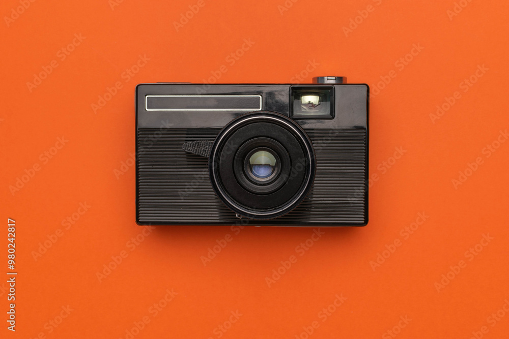 Fototapeta premium Vintage Black Camera on Vibrant Orange Background