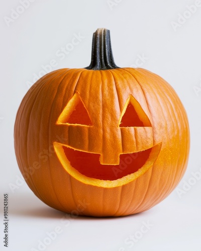 Orange pumpkin with a happy face carving, lit from inside, placed on a clean white background