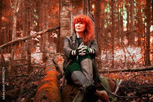 Bild auf Leinwand Mature model portraying a royal huntress with red curve hair resting after hunti