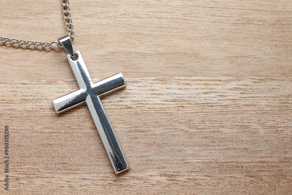 silver cross necklace on wooden table. concept hope, dreams and christianity silver cross necklace on wooden table. concept hope, dreams and christianity