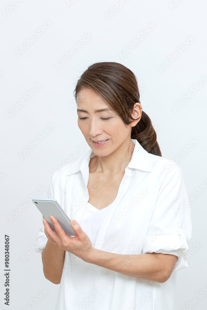 スマートフォンを操作するシニア女性 スマートフォンを操作するシニア女性