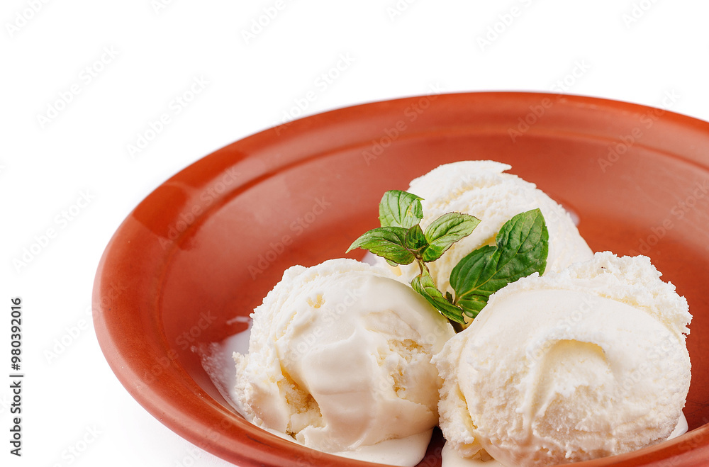 Three scoops of vanilla ice cream melting in rustic bowl with mint garnish Three scoops of vanilla ice cream melting in rustic bowl with mint garnish