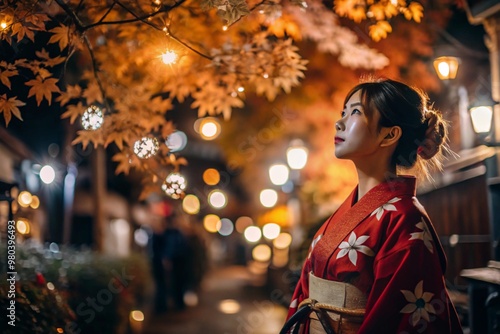 A Japanese girl in a traditional national costume - a kimono. On a fabulous background of lanterns and autumn trees. The portrait symbolizes the traditions and culture of the people of Japan.