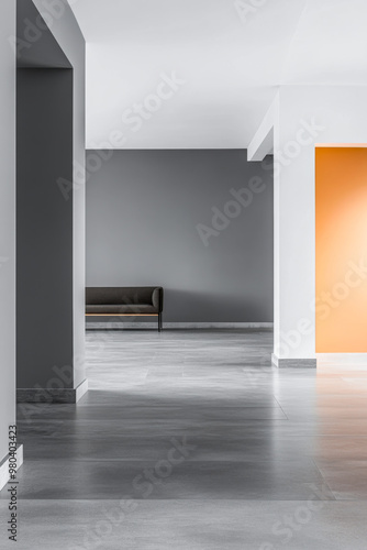 A modern minimalist interior featuring a gray and orange color scheme with a sleek sofa in a spacious hallway