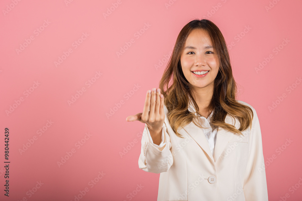 Happy Asian portrait beautiful cute young woman teen smile positive friendly making gesture hand inviting to come here with hand look to camera studio shot isolated on pink background with copy space Happy Asian portrait beautiful cute young woman teen smile positive friendly making gesture hand inviting to come here with hand look to camera studio shot isolated on pink background with copy space
