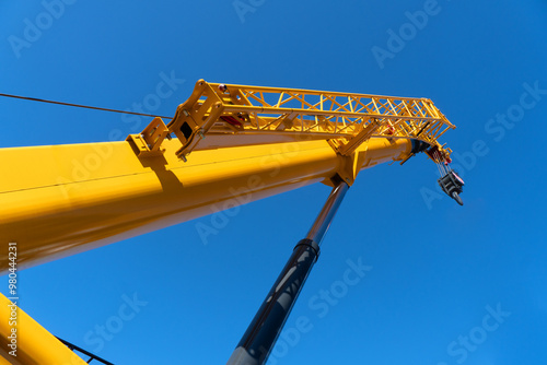 Photography Construction crane arm with hook against blue sky background