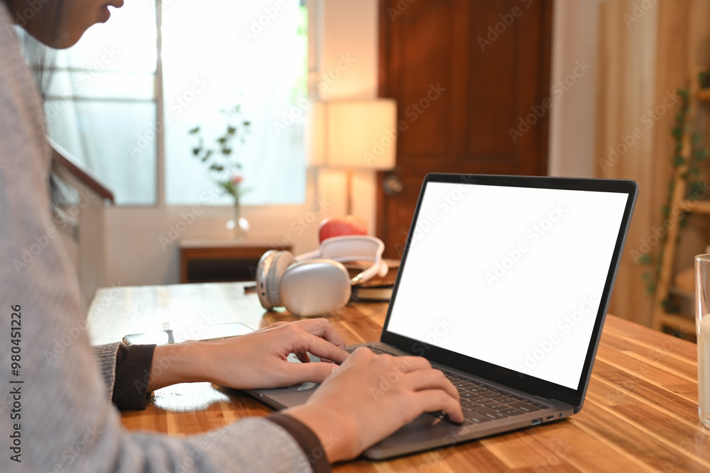 Cropped shot of young woman hands typing on laptop sitting in the kitchen, working and studying Cropped shot of young woman hands typing on laptop sitting in the kitchen, working and studying