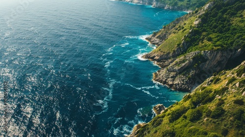 Top view of a greenery mountains seaside. Blue sea with waves. Copy space.