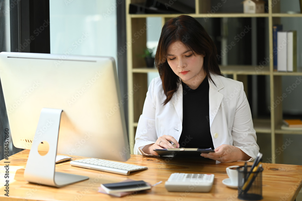 Attractive young businesswoman working at desk in modern office Attractive young businesswoman working at desk in modern office