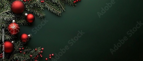 Weihnachtlicher Hintergrund mit Tannenzweigen und Christbaumkugeln auf grünem Untergrund 