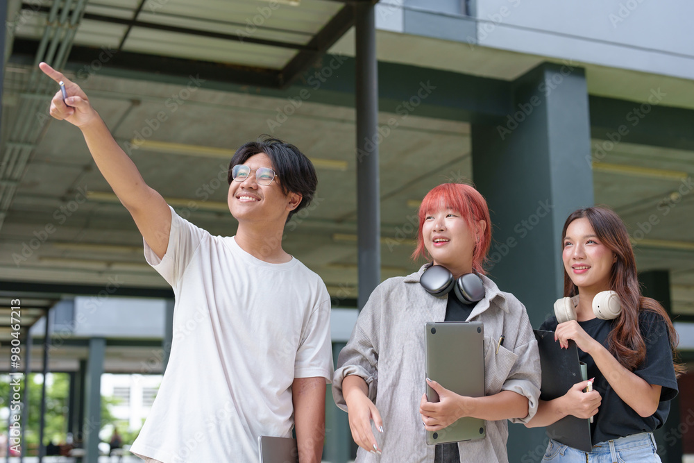 Obraz premium Bright Asian College Student Cheerful people use laptops and tablets to study with a group of classmates. Study outside in a fun way with good friends and social media. Concept of online education.