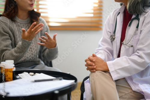 Tablou pe pânză Mature psychiatrist sitting calmly with hands clasped listening attentively to w