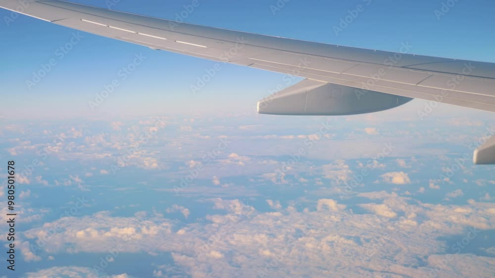 Airplane wing flying high above the clouds in a clear blue sky in 4k Airplane wing flying high above the clouds in a clear blue sky in 4k