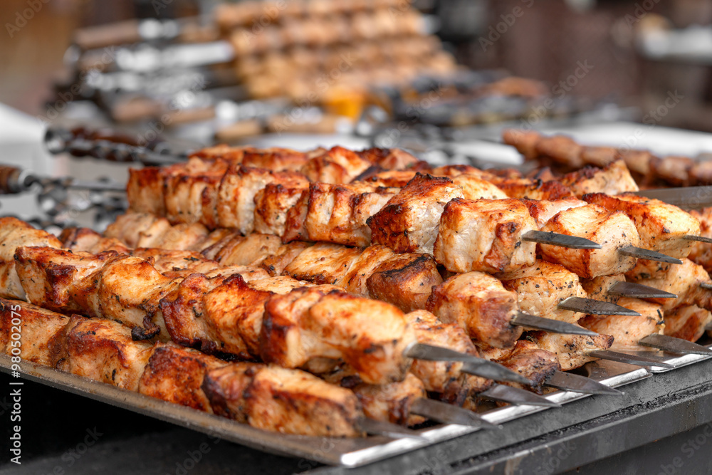 Pork kebab (shish kebab) in close-up. Meat fried on fire (barbecue) on skewers on the market counter. Delicious and mouth-watering shashlik