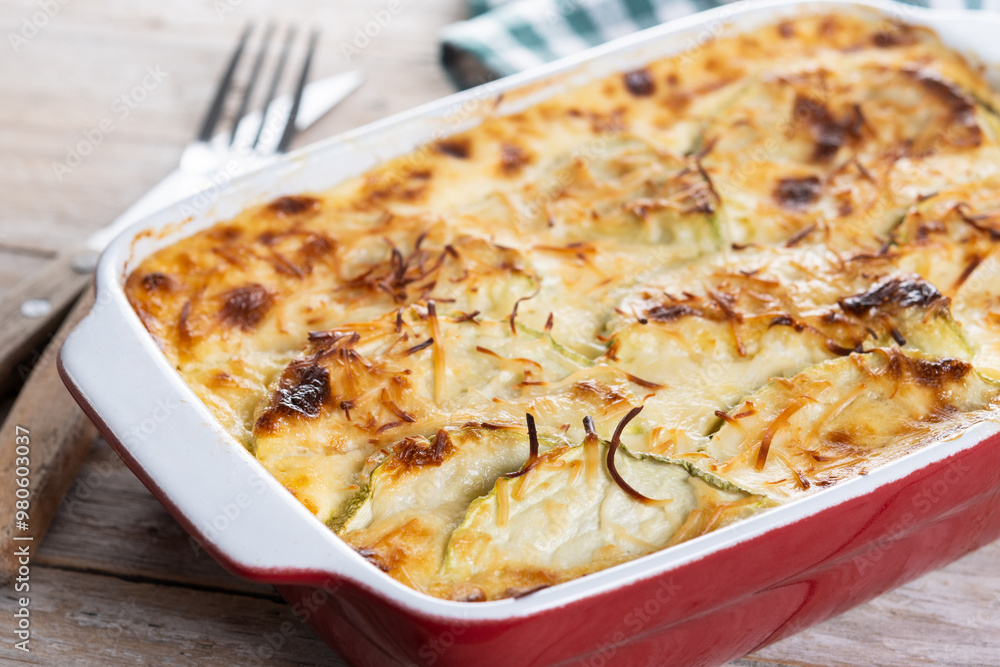 Casserole with cheese and gratin zucchini on wooden table Casserole with cheese and gratin zucchini on wooden table