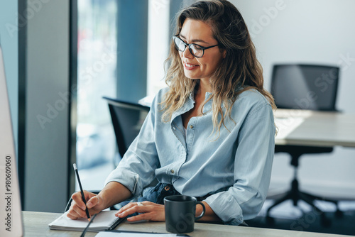 Business woman writing her to do list in a notebook