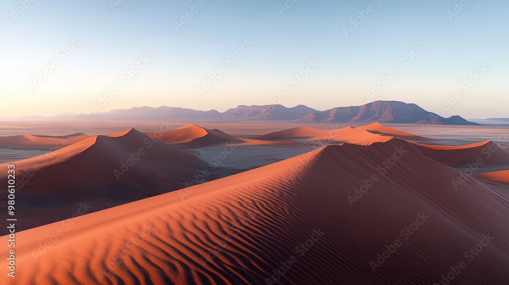 A serene view of rolling sand dunes at sunrise in a desert landscape. A serene view of rolling sand dunes at sunrise in a desert landscape.
