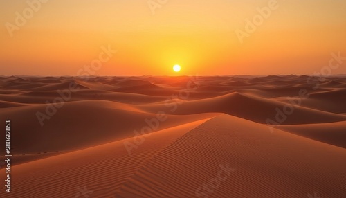 Stunning sunset over golden desert dunes creating a serene landscape.