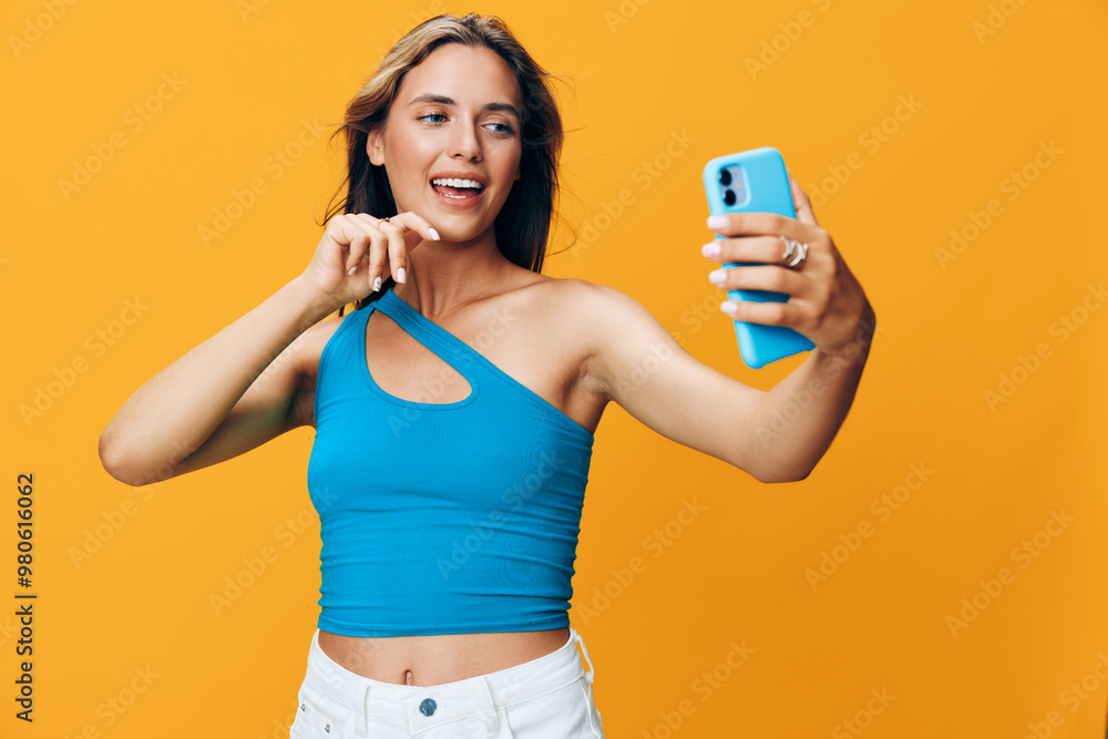 Stylish young woman with blue top and white shorts happily taking a selfie outdoors Stylish young woman with blue top and white shorts happily taking a selfie outdoors