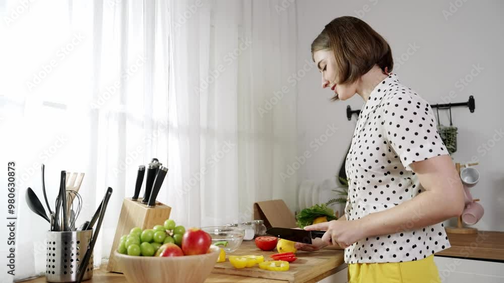 Attractive caucasian mom chopping fresh vegetable for making salad. Happy energetic smart mother working in modern kitchen while cooking healthy food for breakfast. Food preparation concept. Pedagogy. Attractive caucasian mom chopping fresh vegetable for making salad. Happy energetic smart mother working in modern kitchen while cooking healthy food for breakfast. Food preparation concept. Pedagogy.